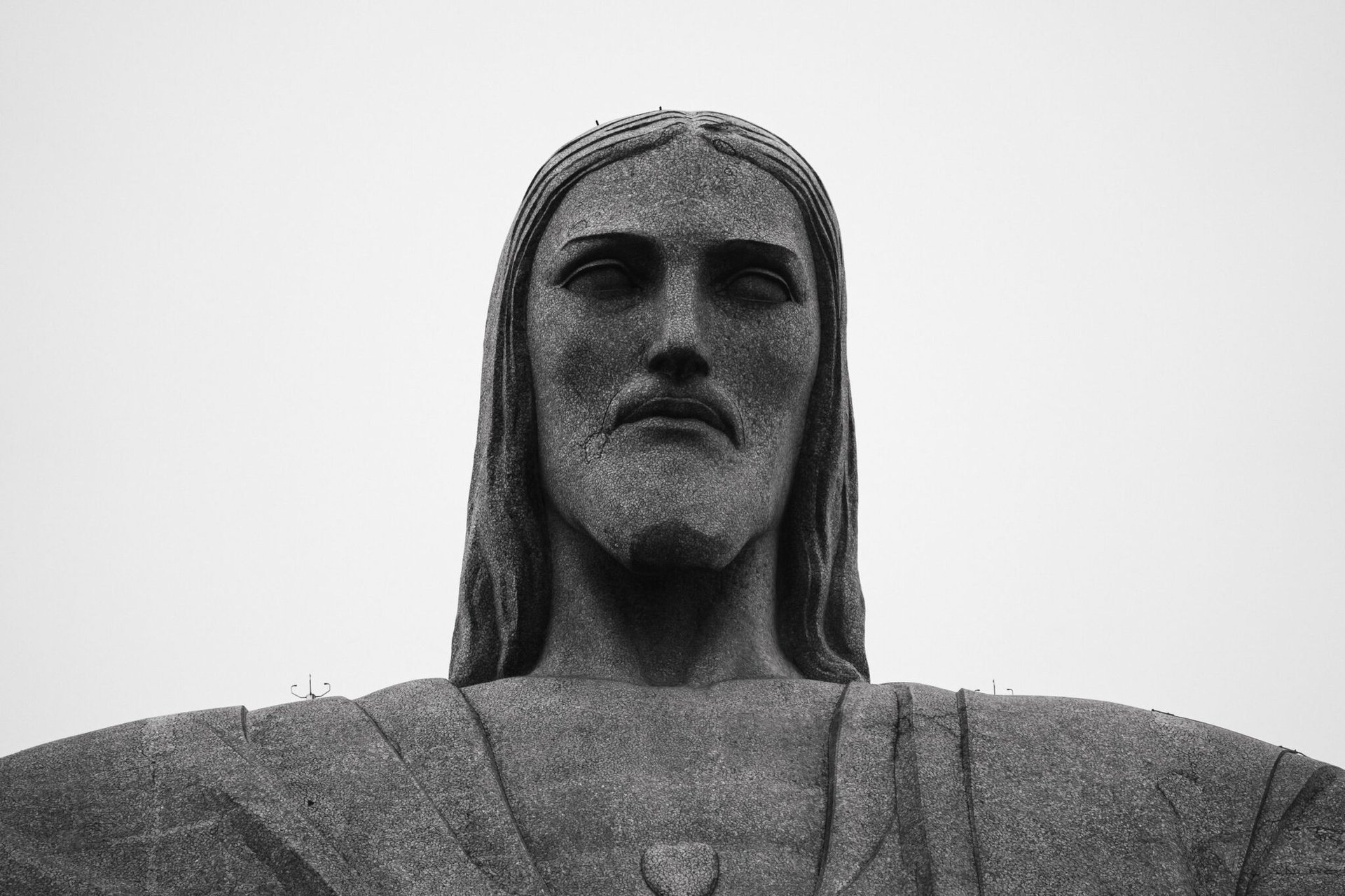 Dramatic black and white close-up of the iconic Christ the Redeemer statue in Rio de Janeiro, Brazil.