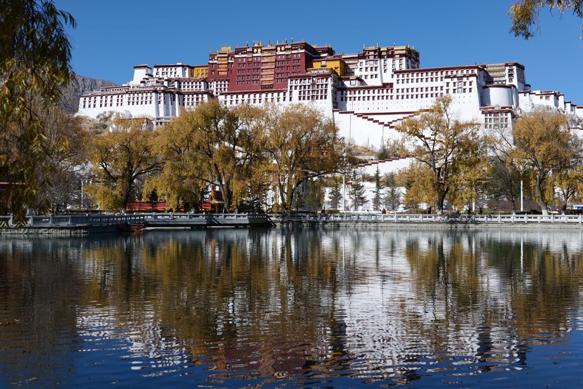 Stunning view of Potala Palace with its reflection in serene water in Lhasa, Tibet.