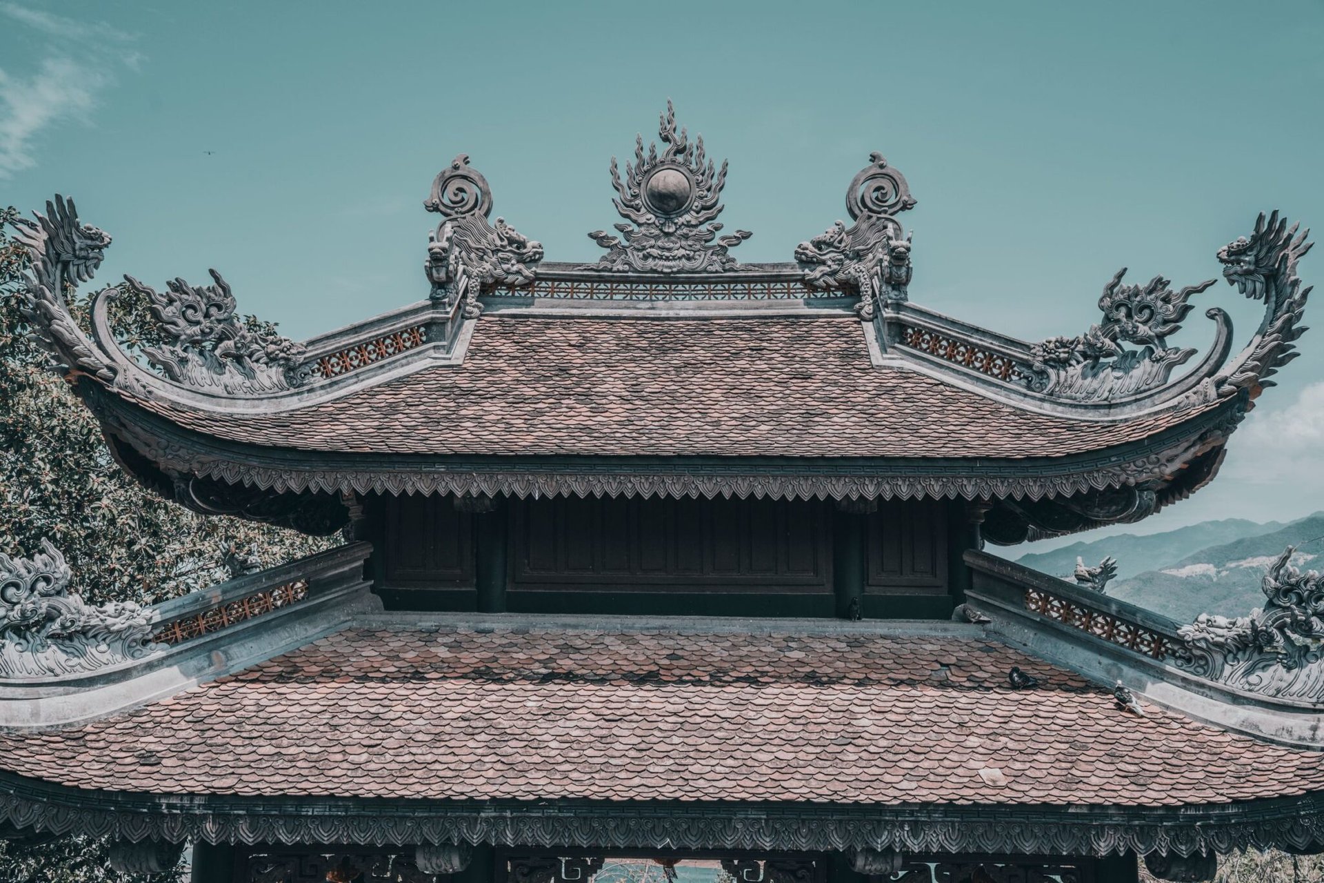 Intricate rooftop of an ancient Asian temple showcasing detailed architectural craftsmanship.