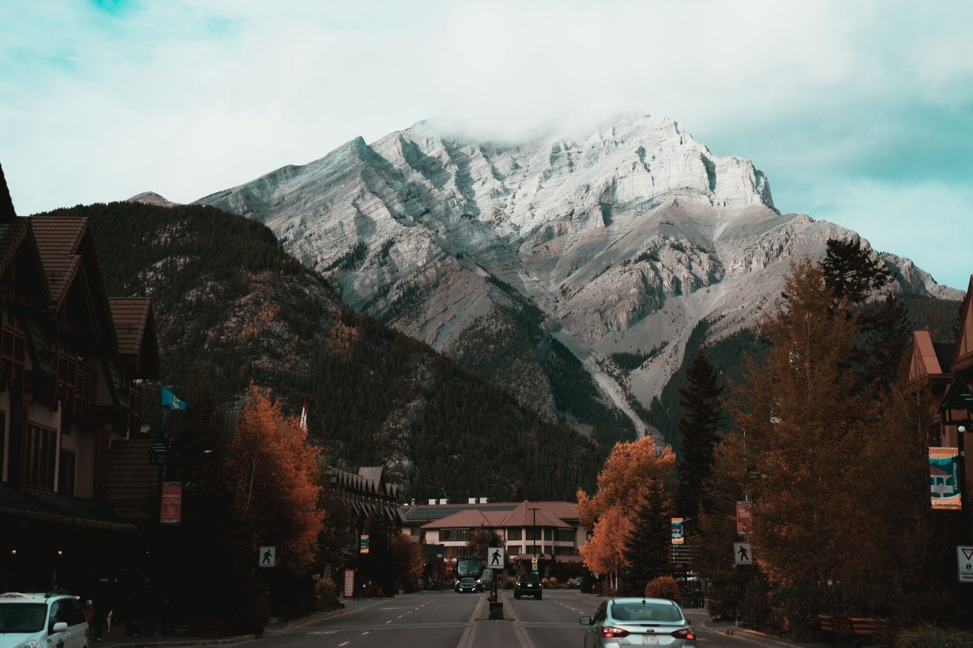 Picturesque Banff, Canada with mountains and autumn trees lining the road.