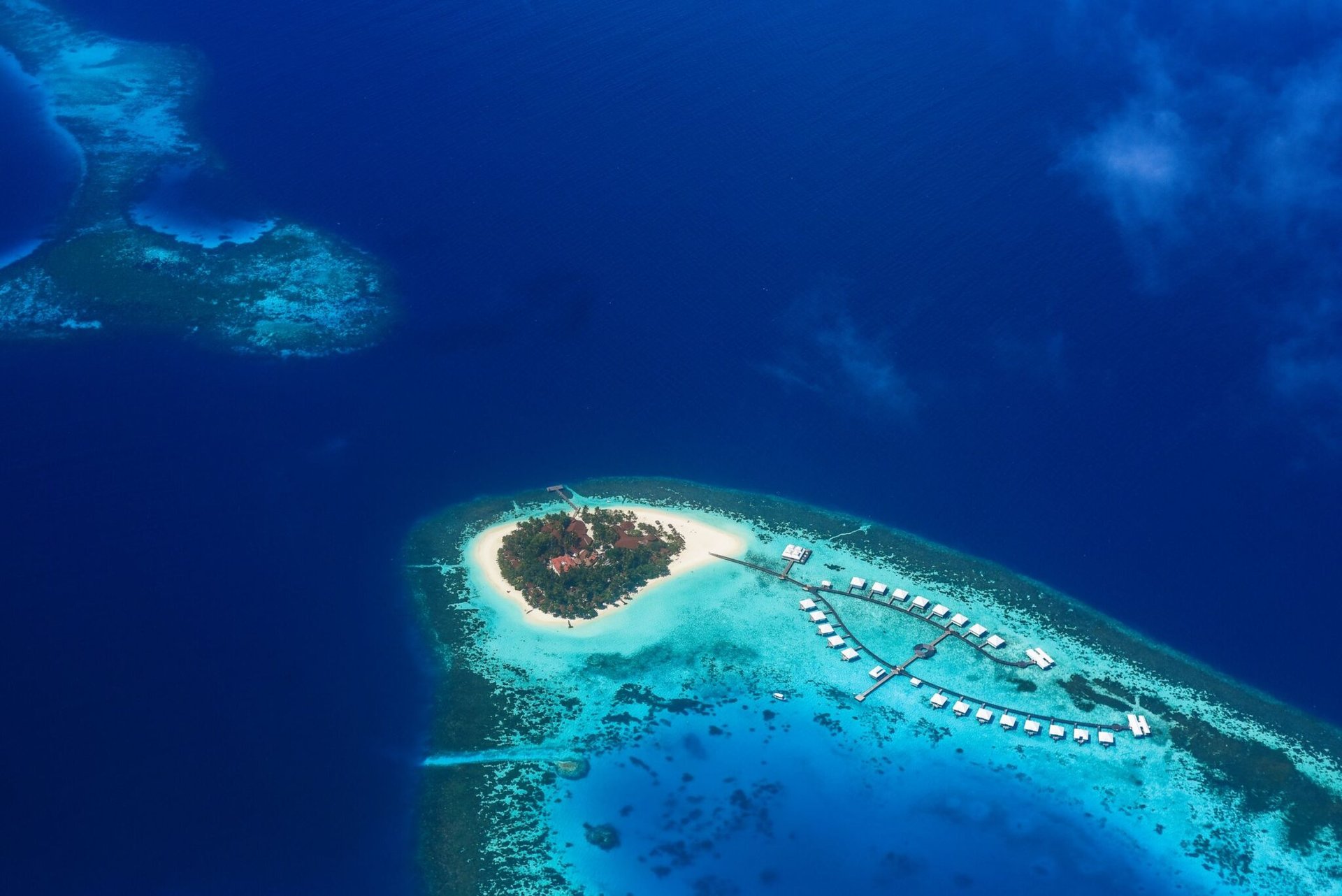 Stunning aerial shot of a tropical island paradise surrounded by turquoise waters in the Maldives.