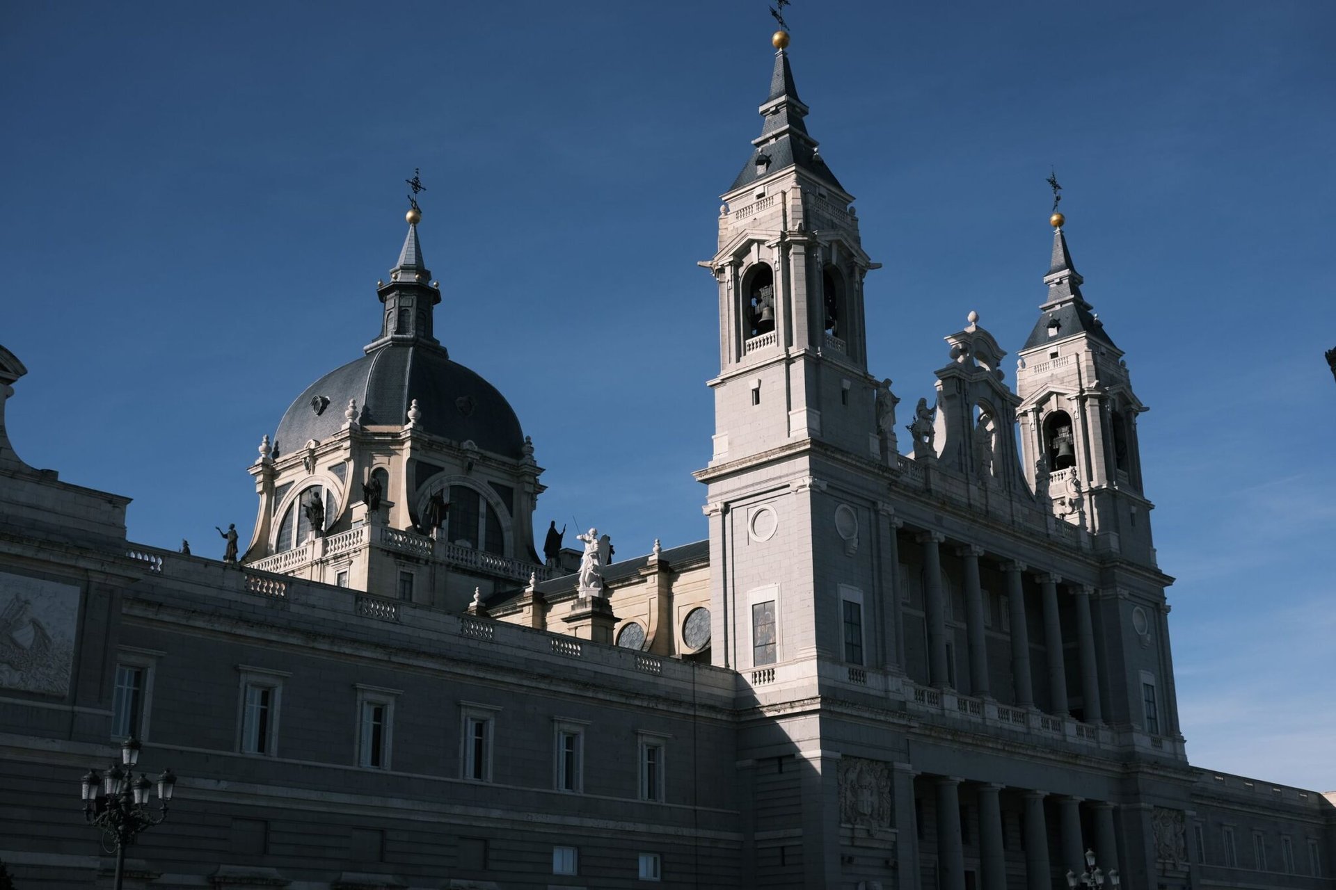 Majestic view of the Almudena Cathedral lit by the sun in Madrid, Spain. Ideal for travel and architecture enthusiasts.