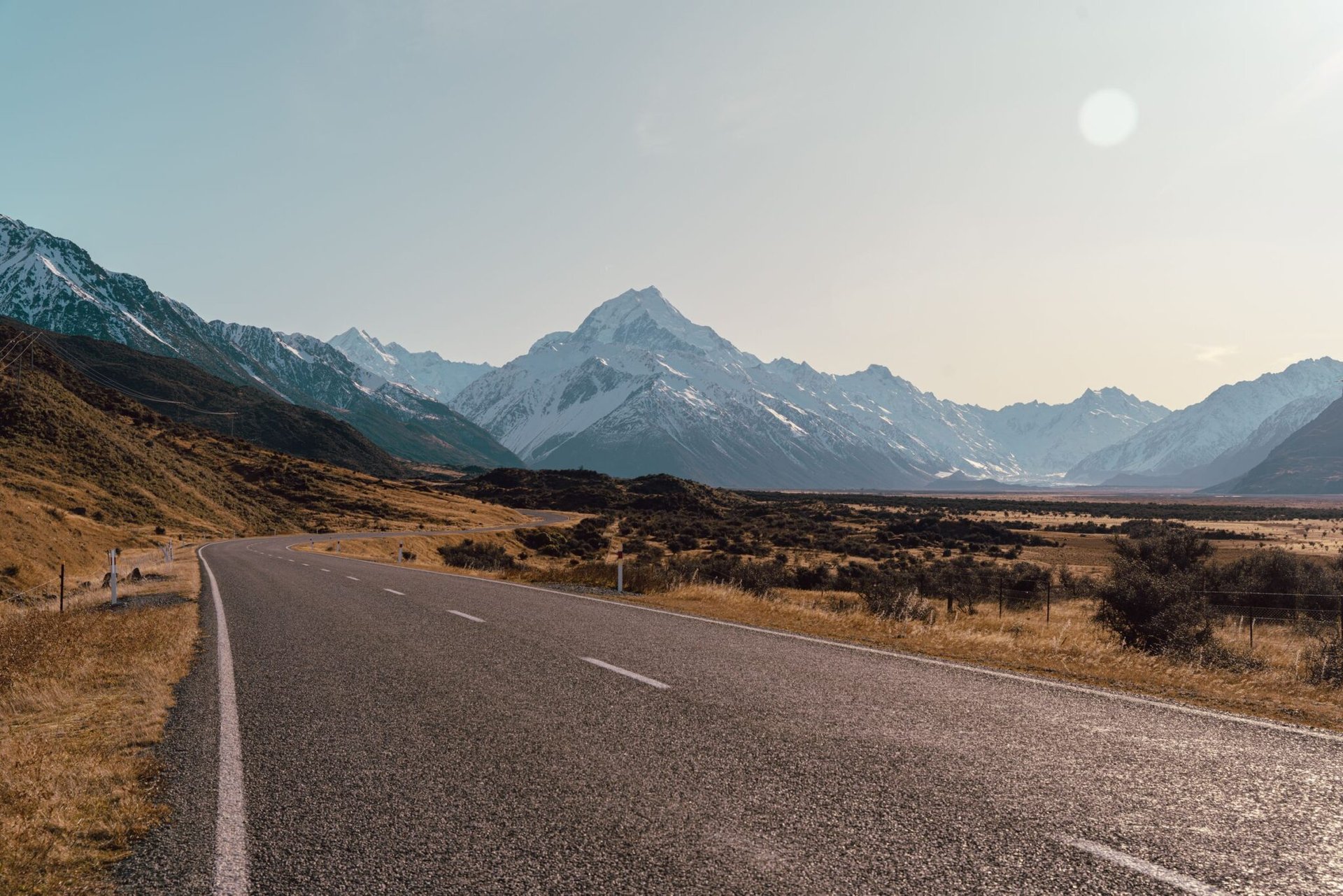 Open road leading to Aoraki Mount Cook, framed by stunning alpine mountains in New Zealand.