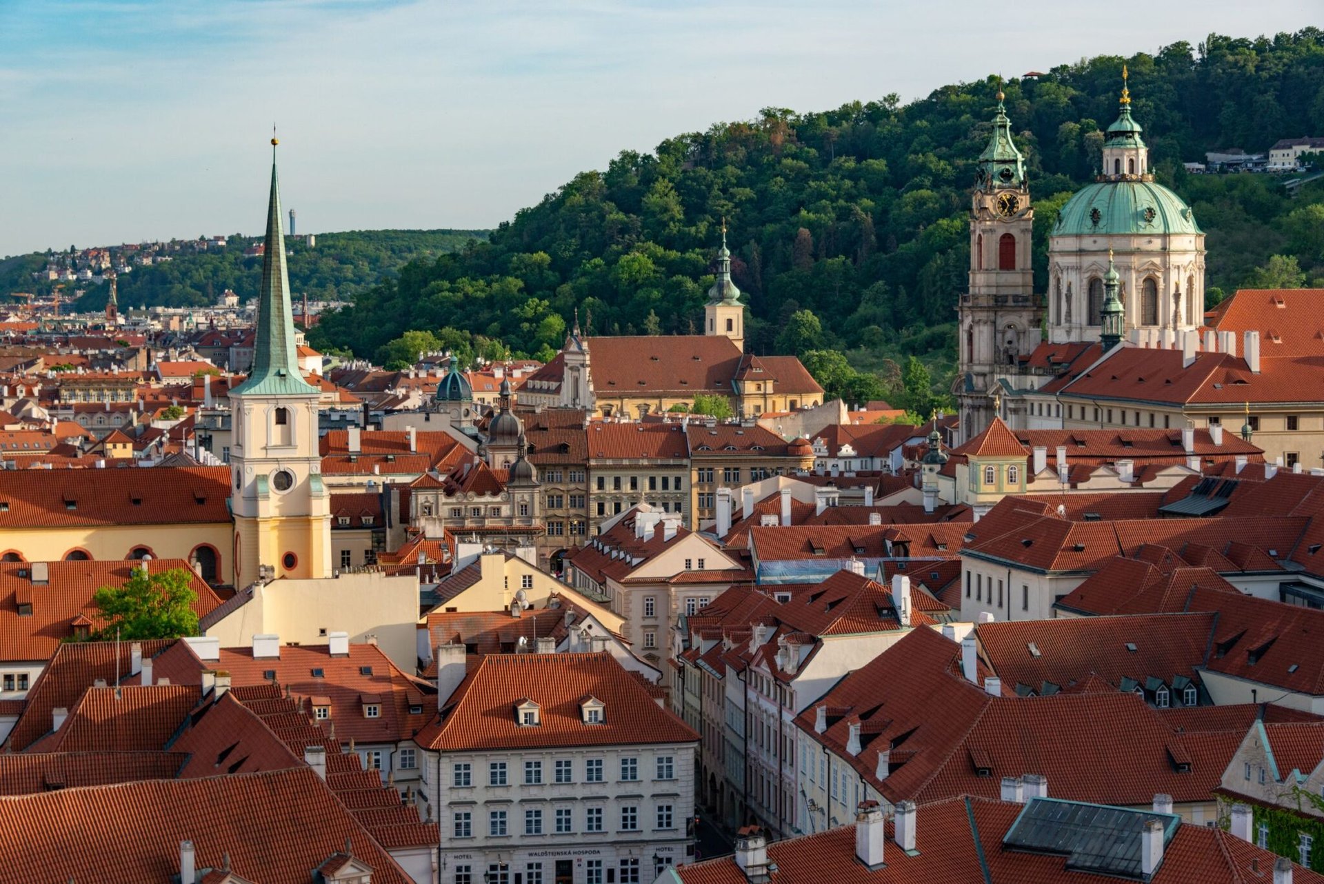 Aerial view of historical St. Nicholas Church and rooftops in Prague's old town.