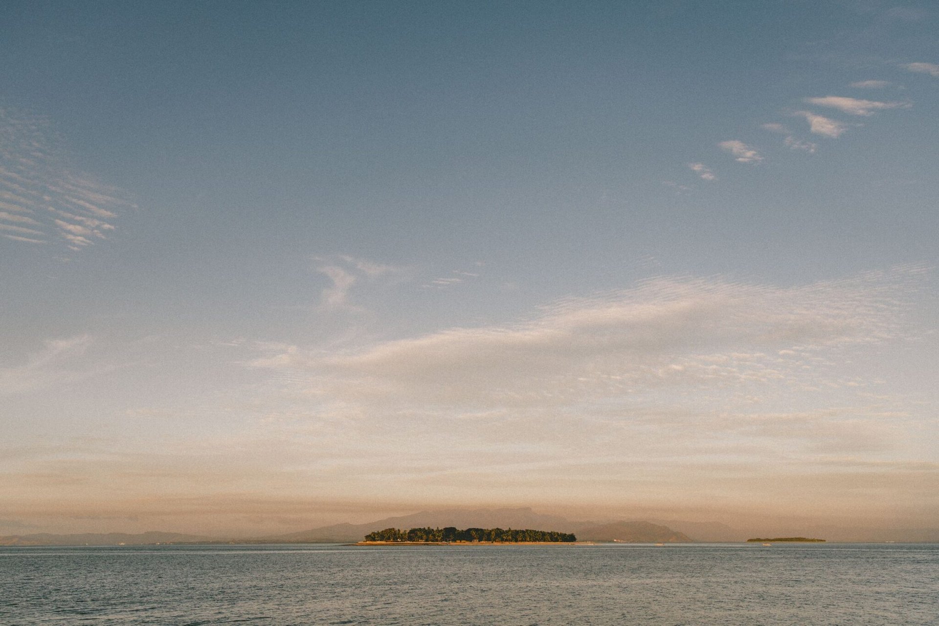 Beautiful view of a serene island and ocean under a glowing sunrise in Fiji.