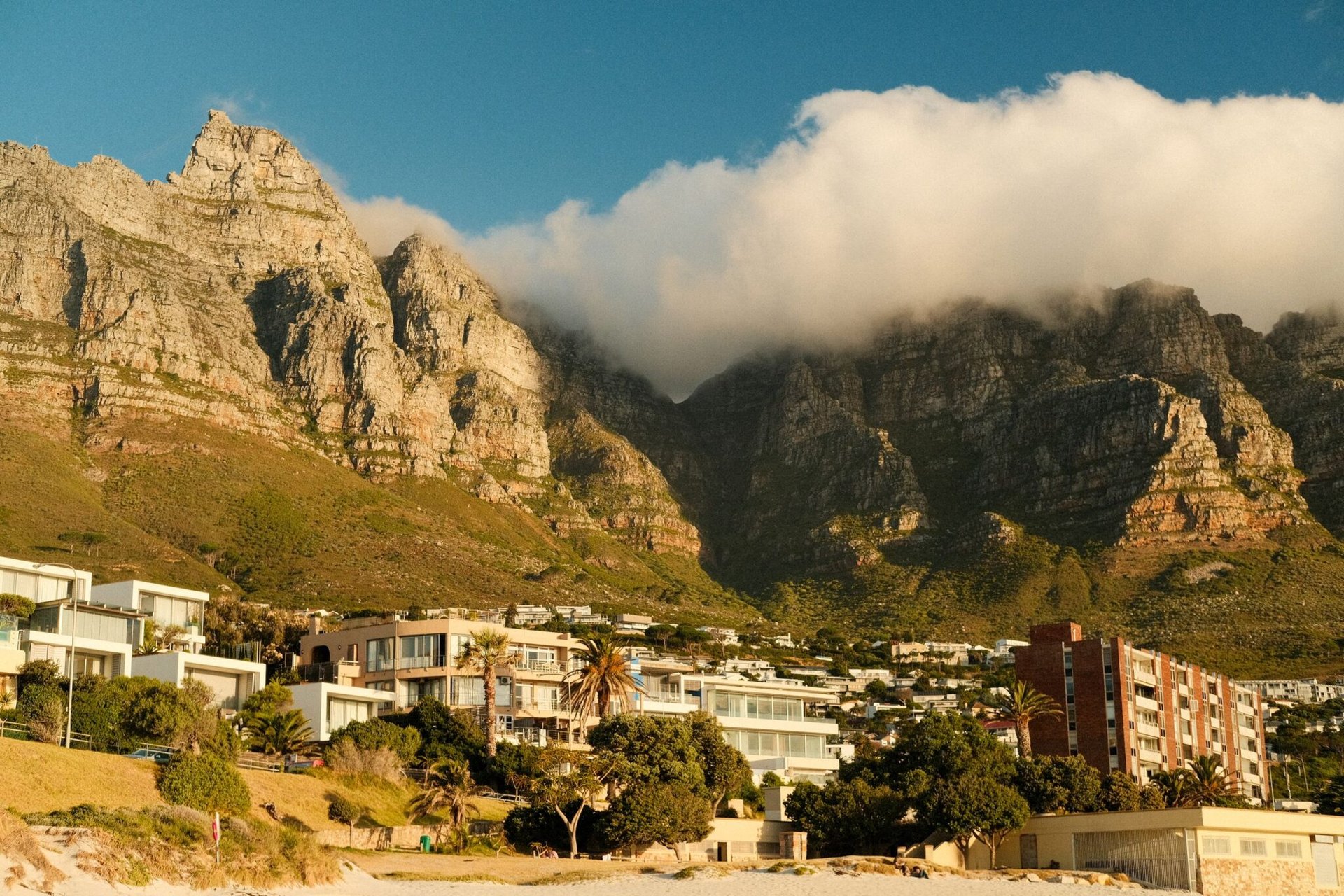 Capture of the iconic Twelve Apostles with clouds and coastal buildings in Cape Town, South Africa.