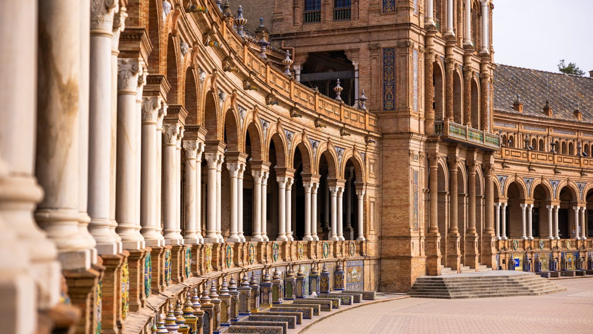 Elegant arches and ornate architecture of Plaza de España in Seville, Spain, showcasing historical grandeur.