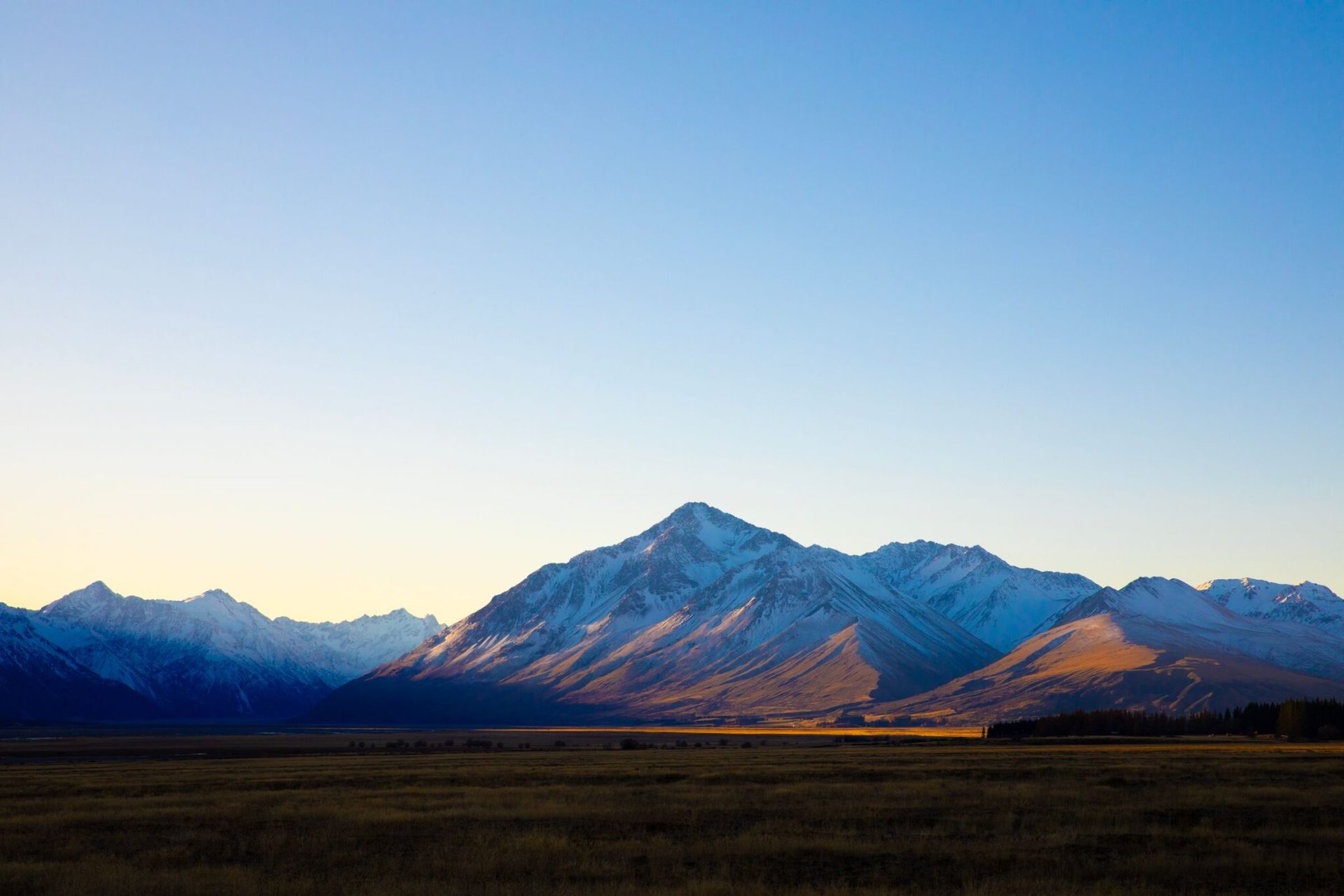 Stunning view of the Southern Alps mountains during sunrise in New Zealand, showcasing serene natural beauty.