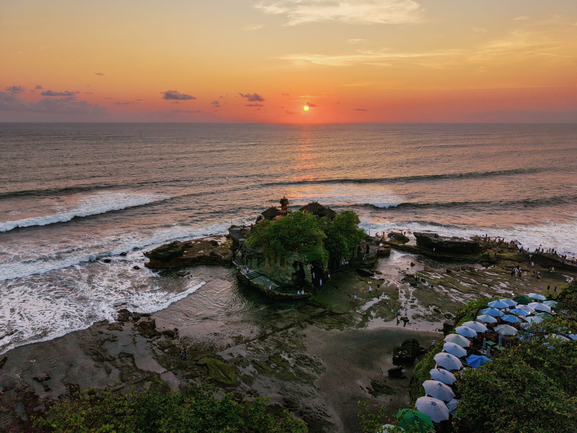 Beautiful sunset view of Tanah Lot Temple, Bali, Indonesia, with ocean waves.