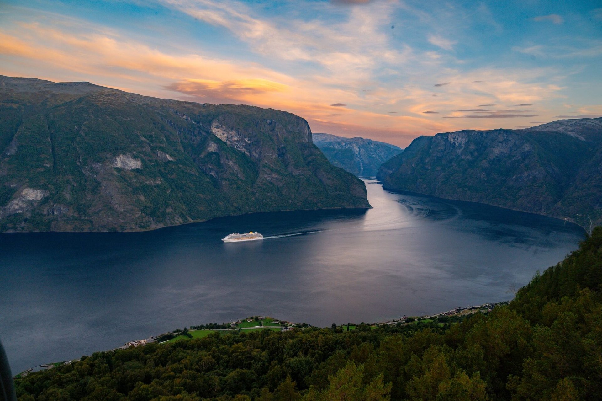 Tranquil sunset view of a cruise ship in Aurlandsfjord, Norway’s stunning landscape.