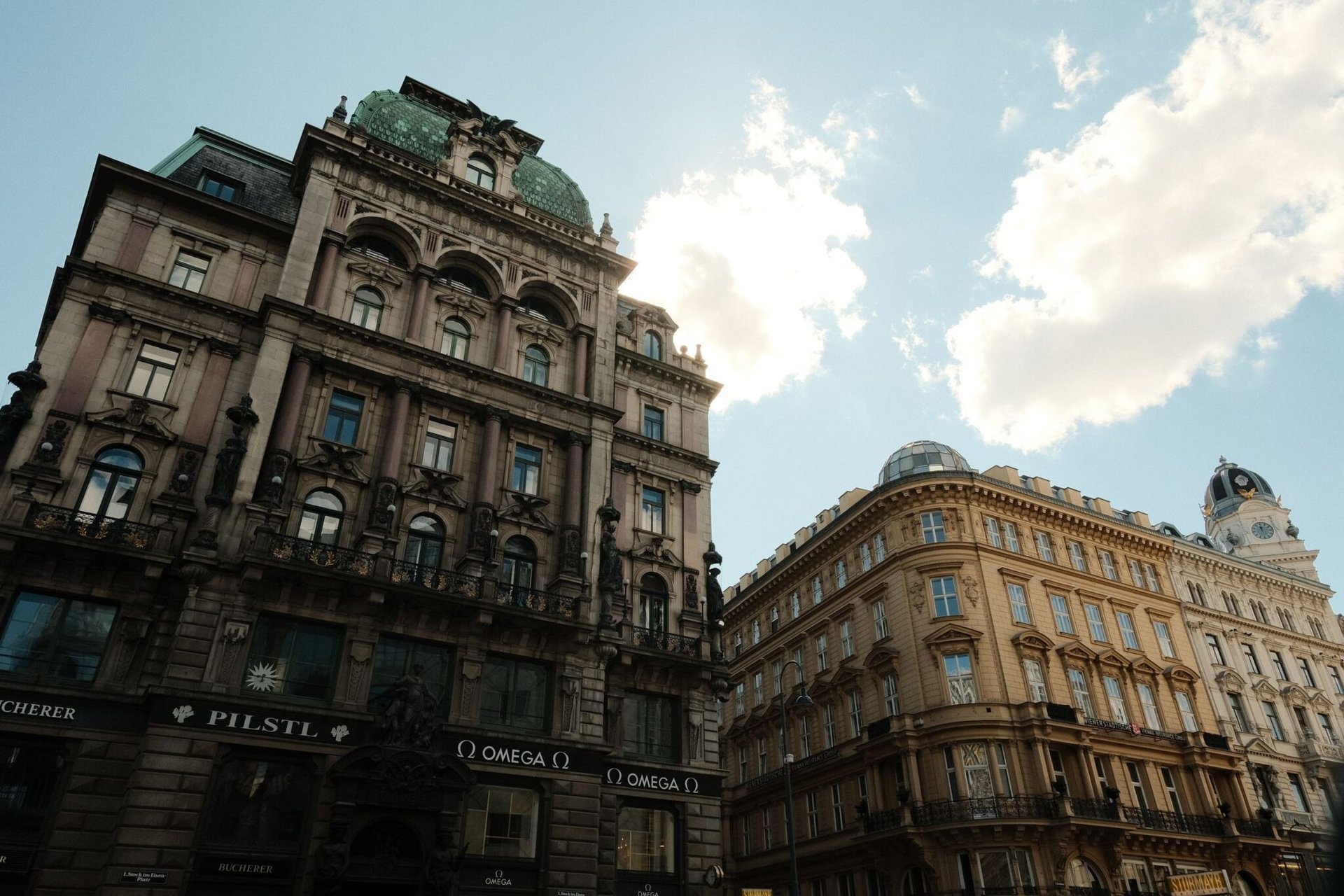 Elegant historic buildings in Vienna, Austria under a bright sky, showcasing intricate architecture.