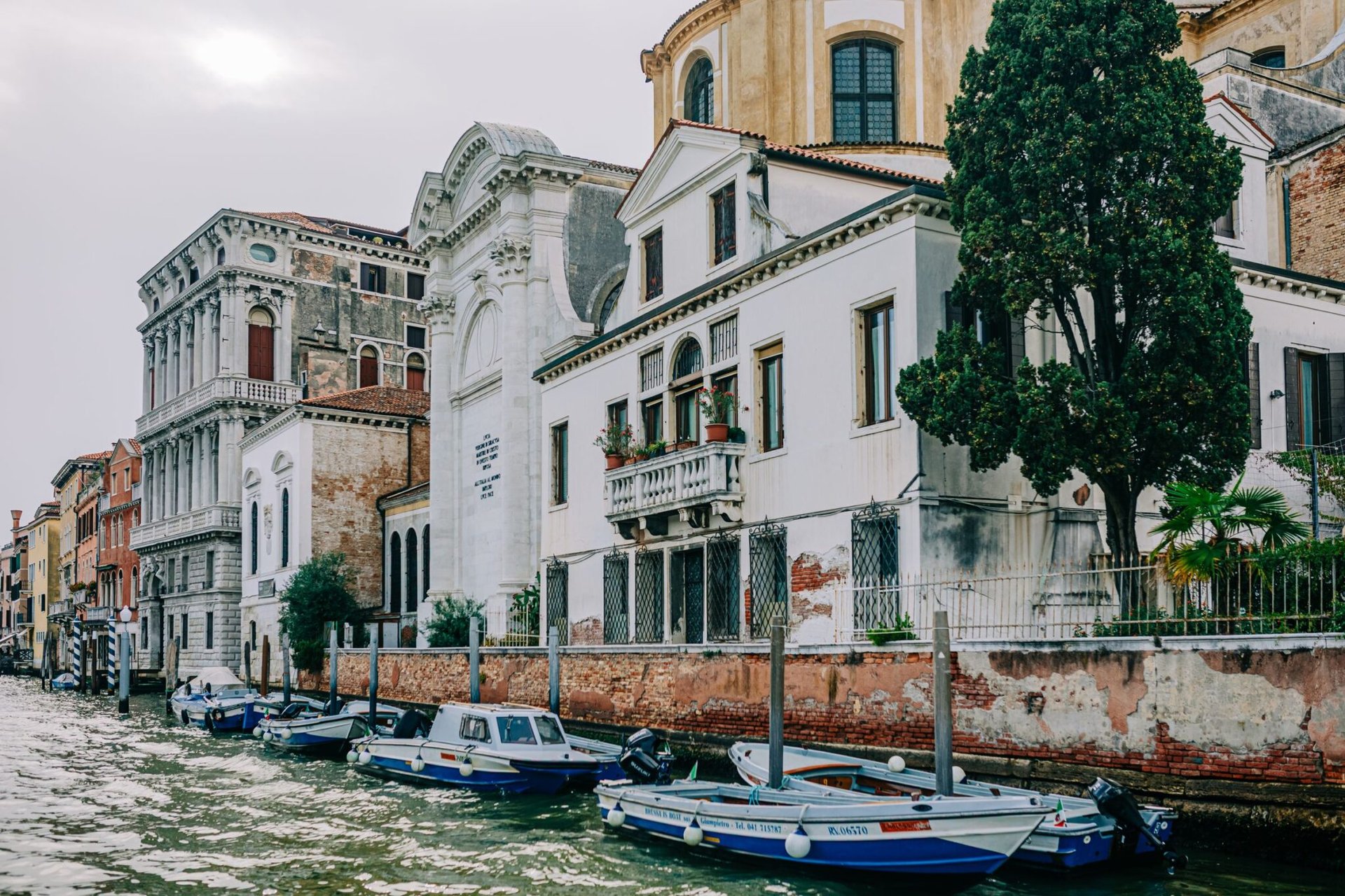 Picturesque view of Venice canal with historic architecture and boats reflecting the charm of Italy.