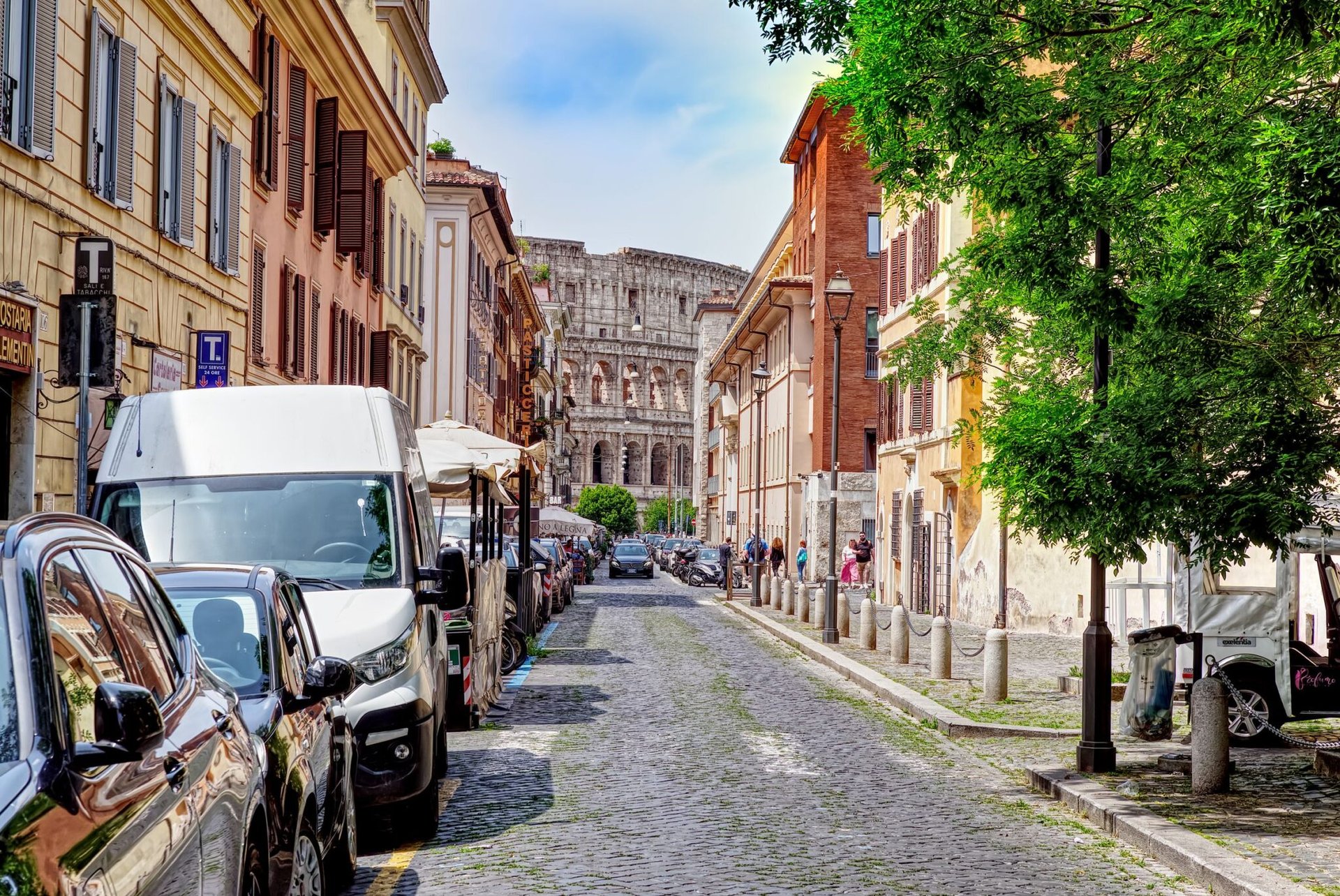 Charming street in Rome with Colosseum in view, vibrant and historic atmosphere.