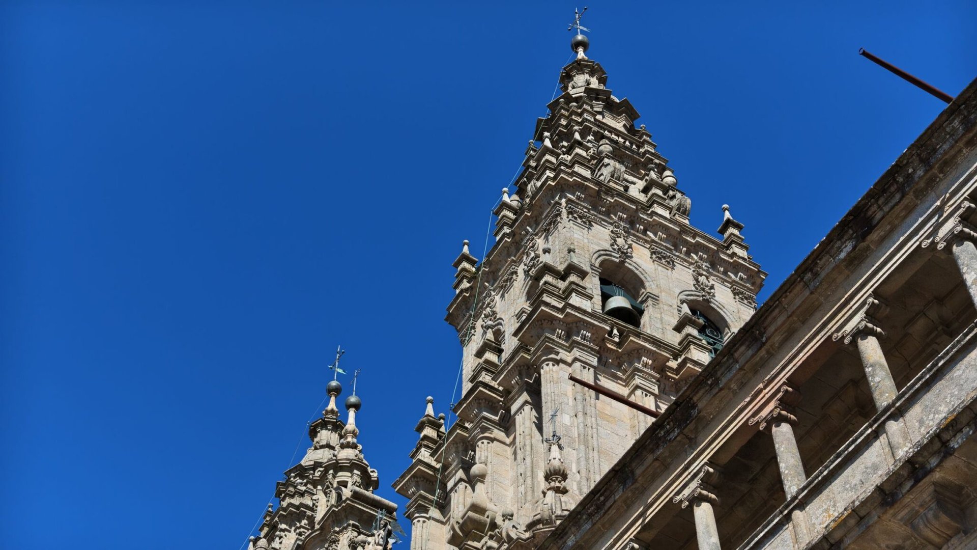 The Cathedral of Santiago de Compostela's ornate towers set against a vibrant blue sky.