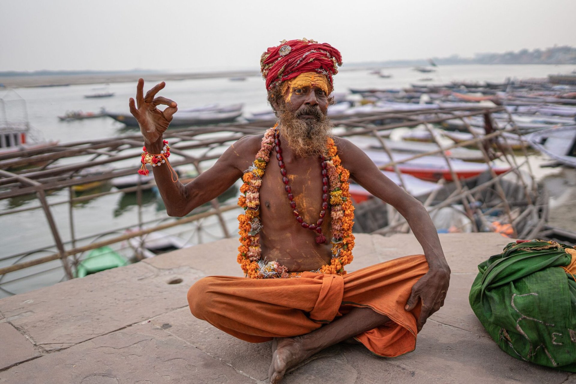 A traditional sadhu meditating beside the Ganges River in Varanasi, exuding peace and spirituality.