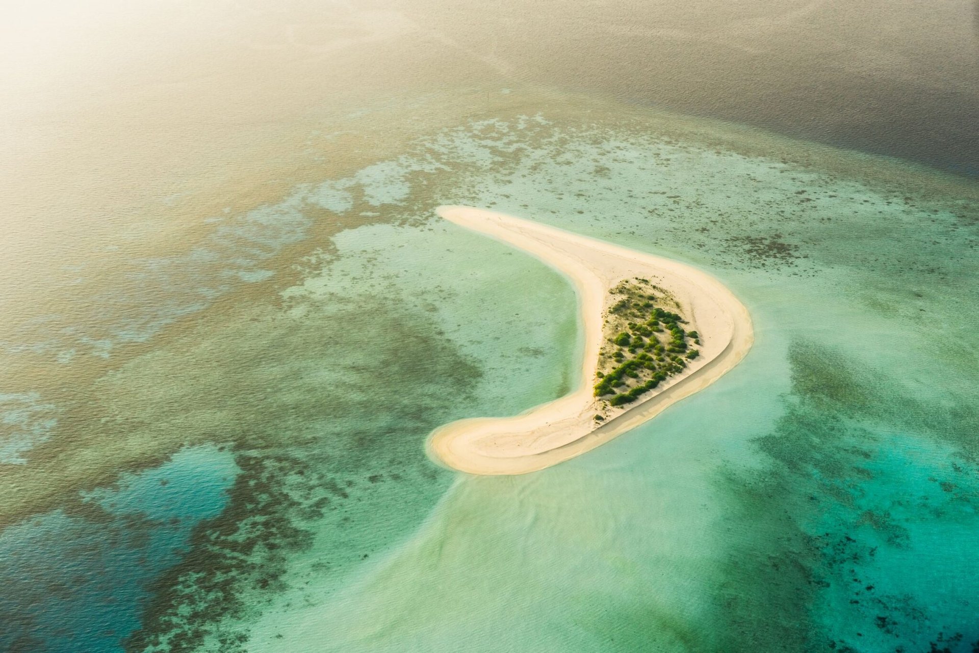 Stunning aerial view of a secluded sandbank surrounded by turquoise waters in the Maldives.