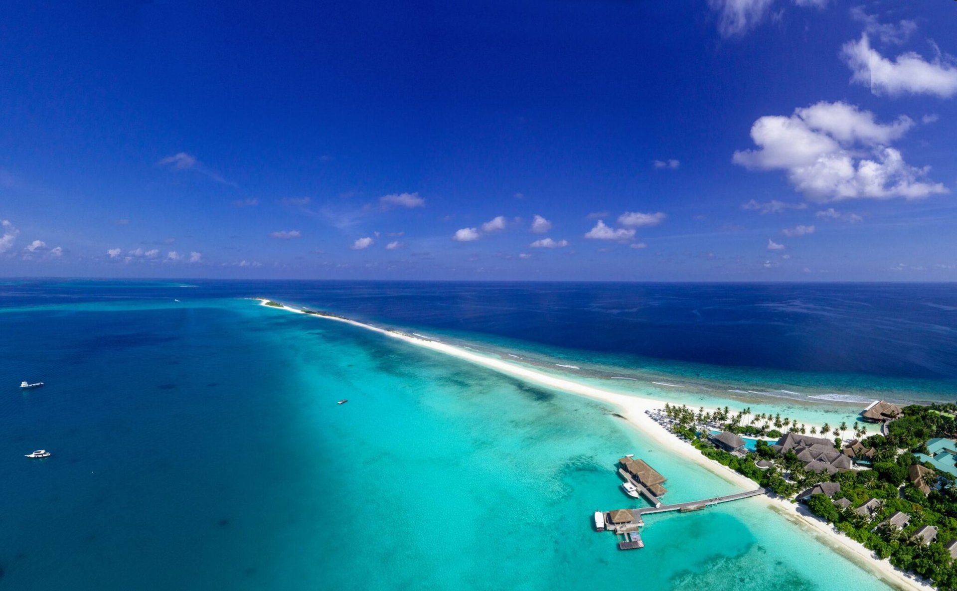 Stunning aerial view of a tropical island in the Maldives with pristine beaches and clear blue waters.