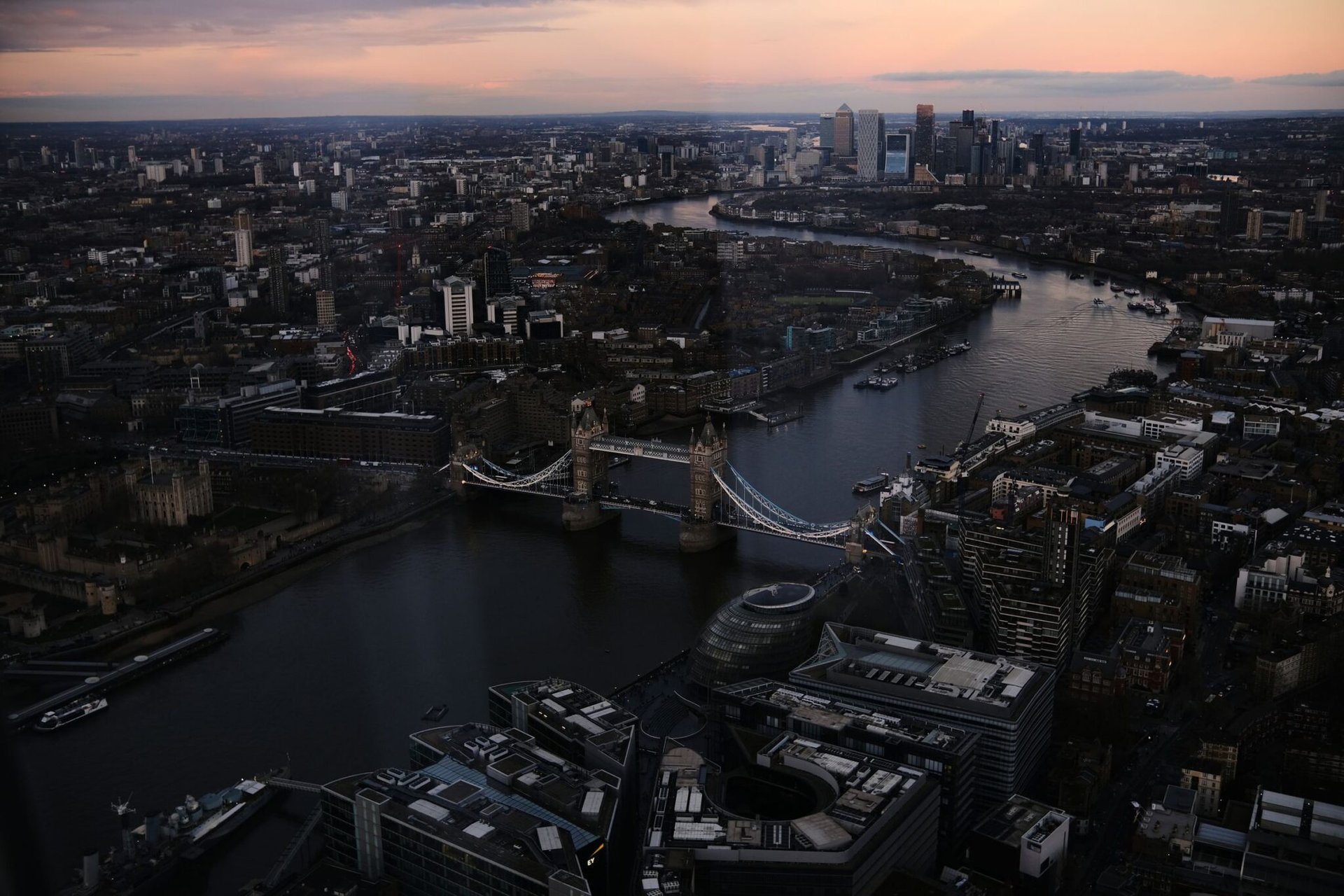 Stunning aerial view of London featuring Tower Bridge and Thames River during sunset.