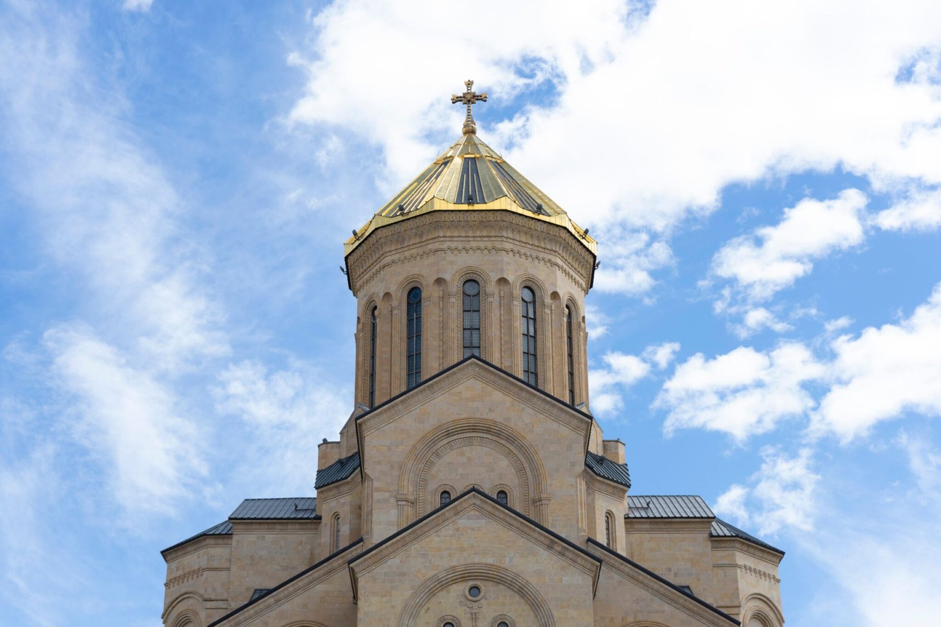 The stunning architecture of the Holy Trinity Cathedral against a blue sky in Tbilisi, Georgia.