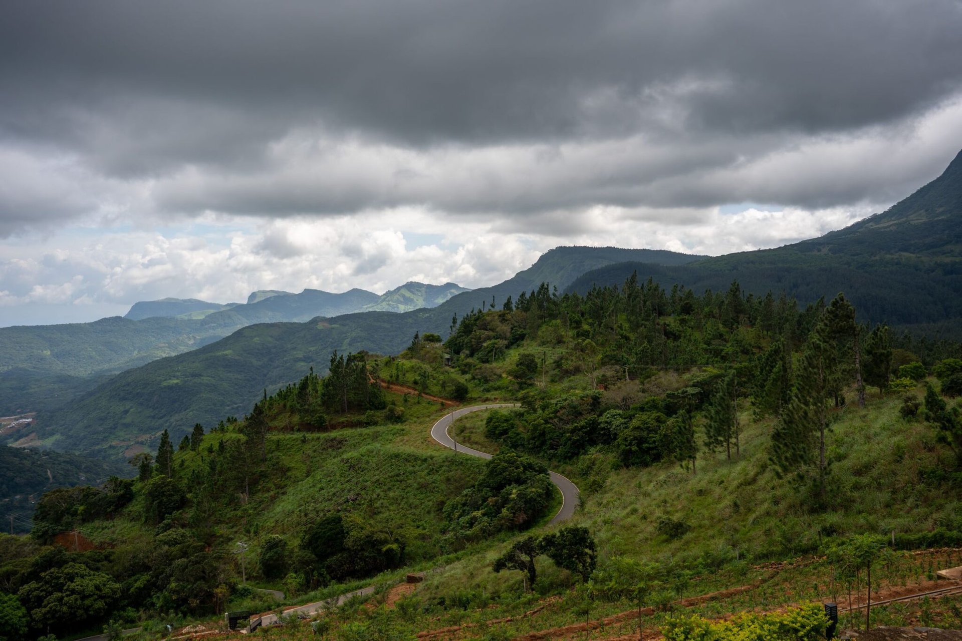 Stunning landscape of Hunnasgiriya's lush hills under a dramatic cloudy sky in Sri Lanka.