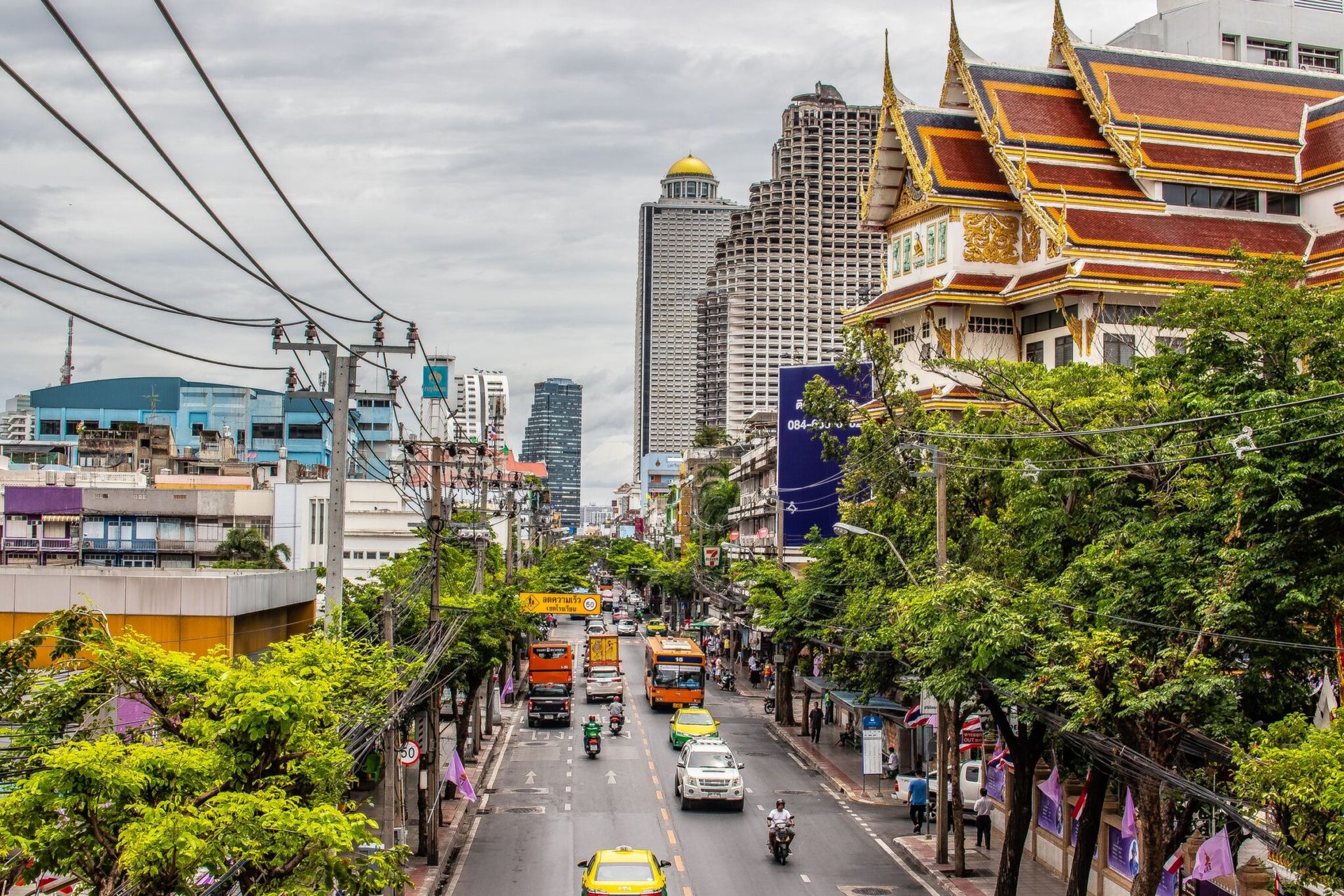 Bustling Bangkok street with traffic and iconic architecture. Urban life in Thailand's capital.