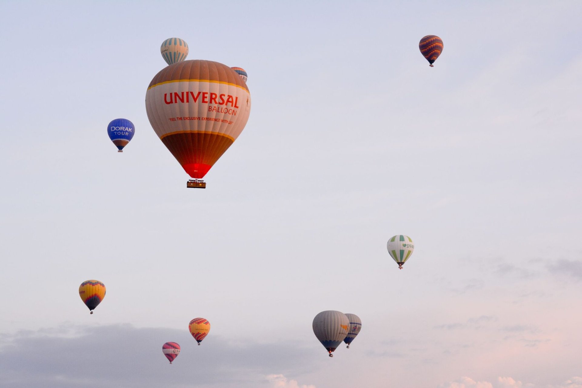 A scenic view of hot air balloons floating in the sky over Cappadocia, Türkiye.