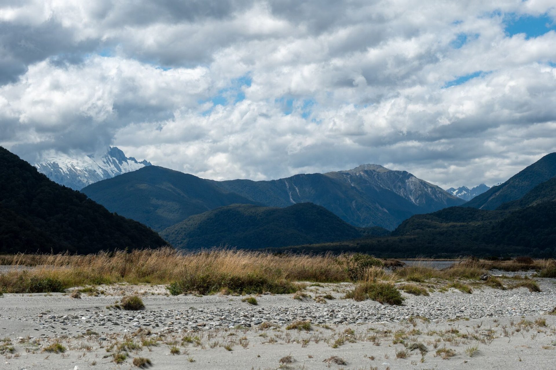 Breathtaking view of New Zealand mountains under a cloudy sky, showcasing nature's beauty.