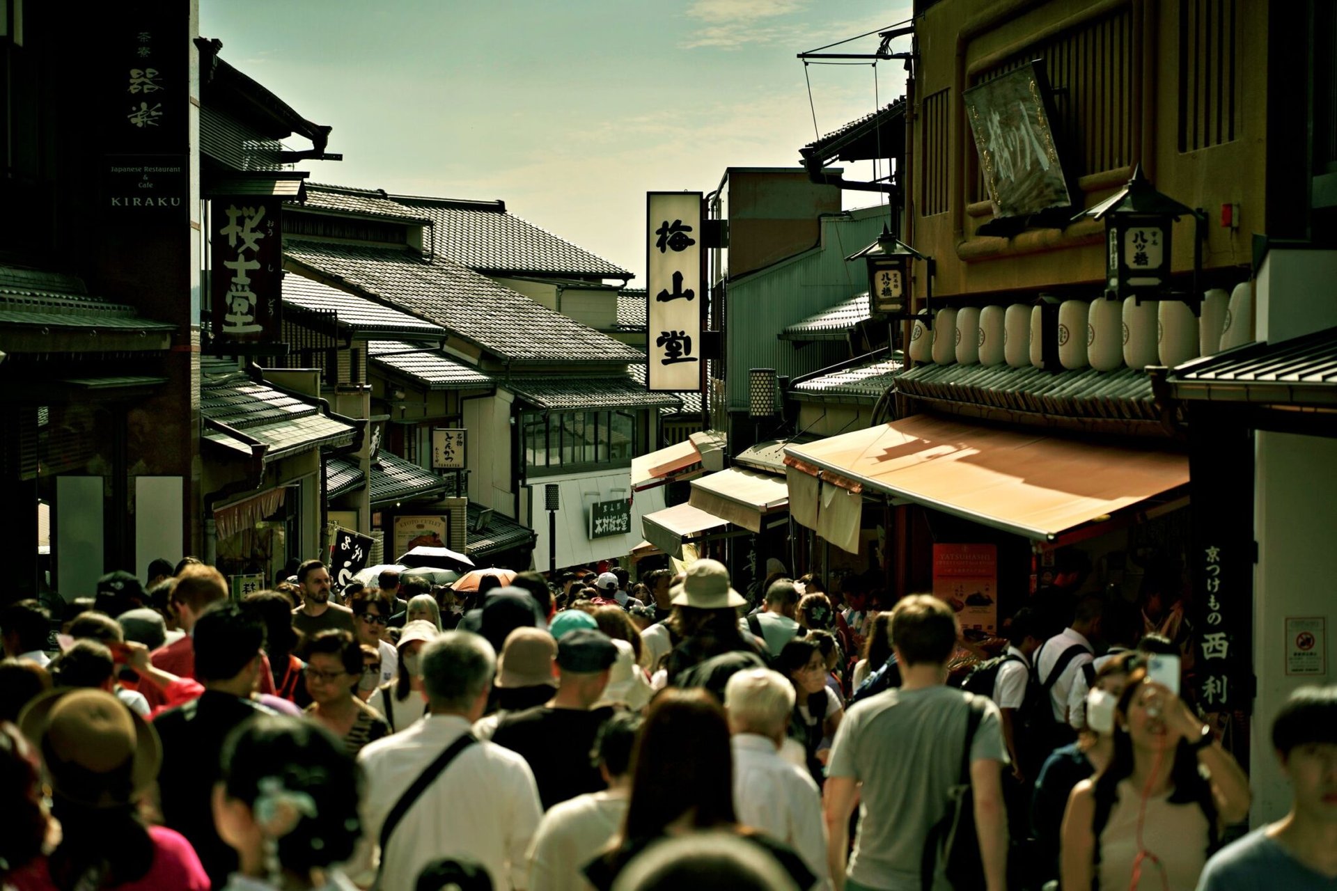 Busy pedestrian street in Kyoto, Japan, showcasing traditional architecture and vibrant life.