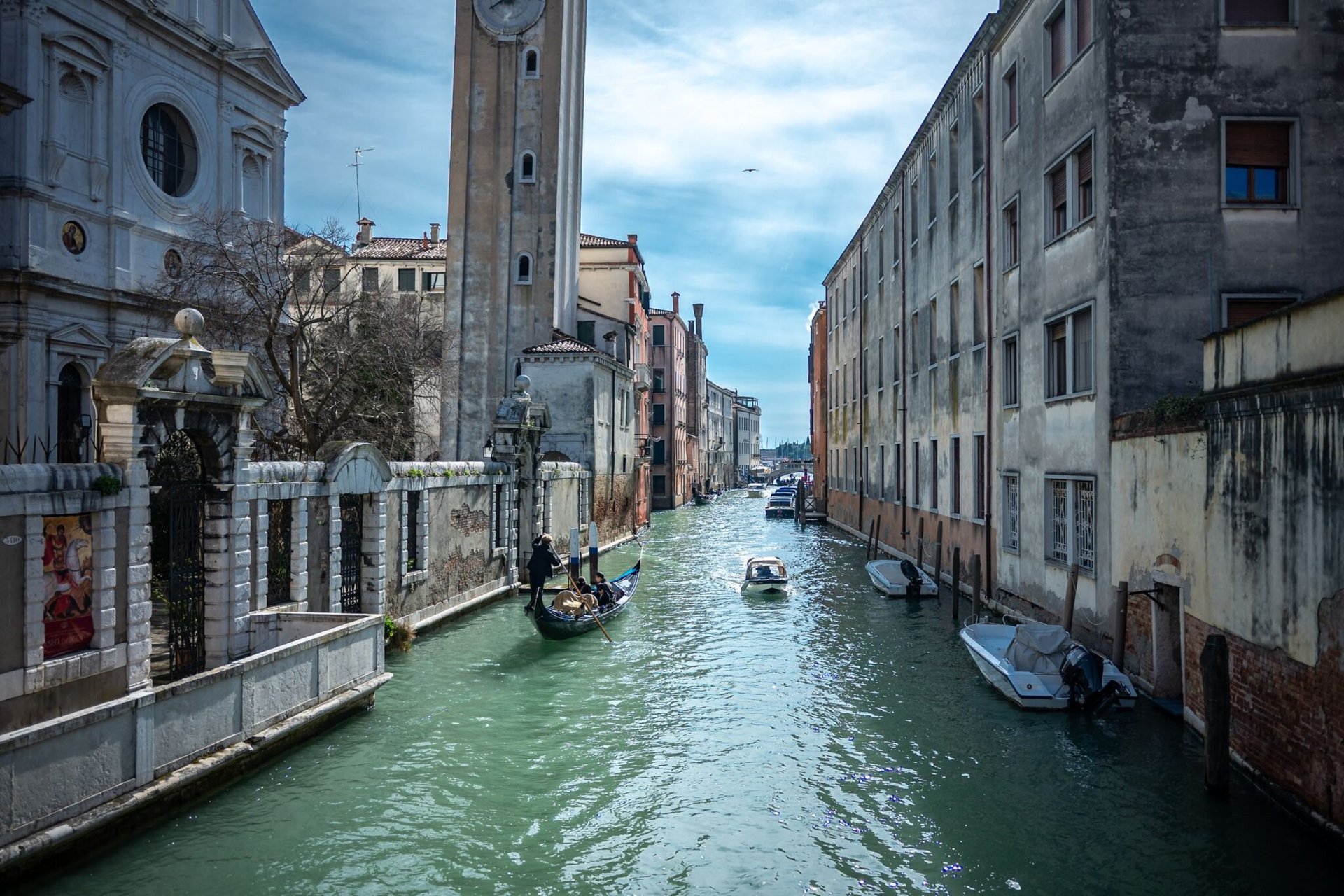 Picturesque view of a canal in Venice, Italy, featuring a gondola and historic architecture under a clear sky.