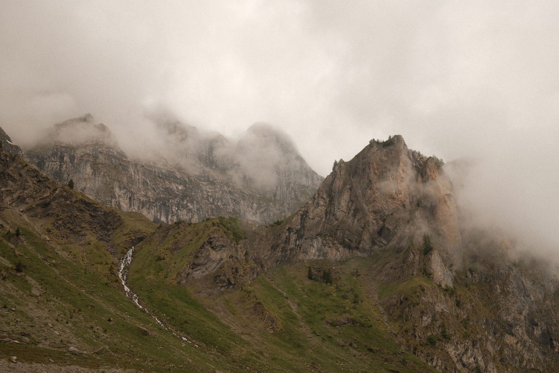 Fog shrouded peaks of the Swiss Alps in Wolfenschiessen, Switzerland during summer.