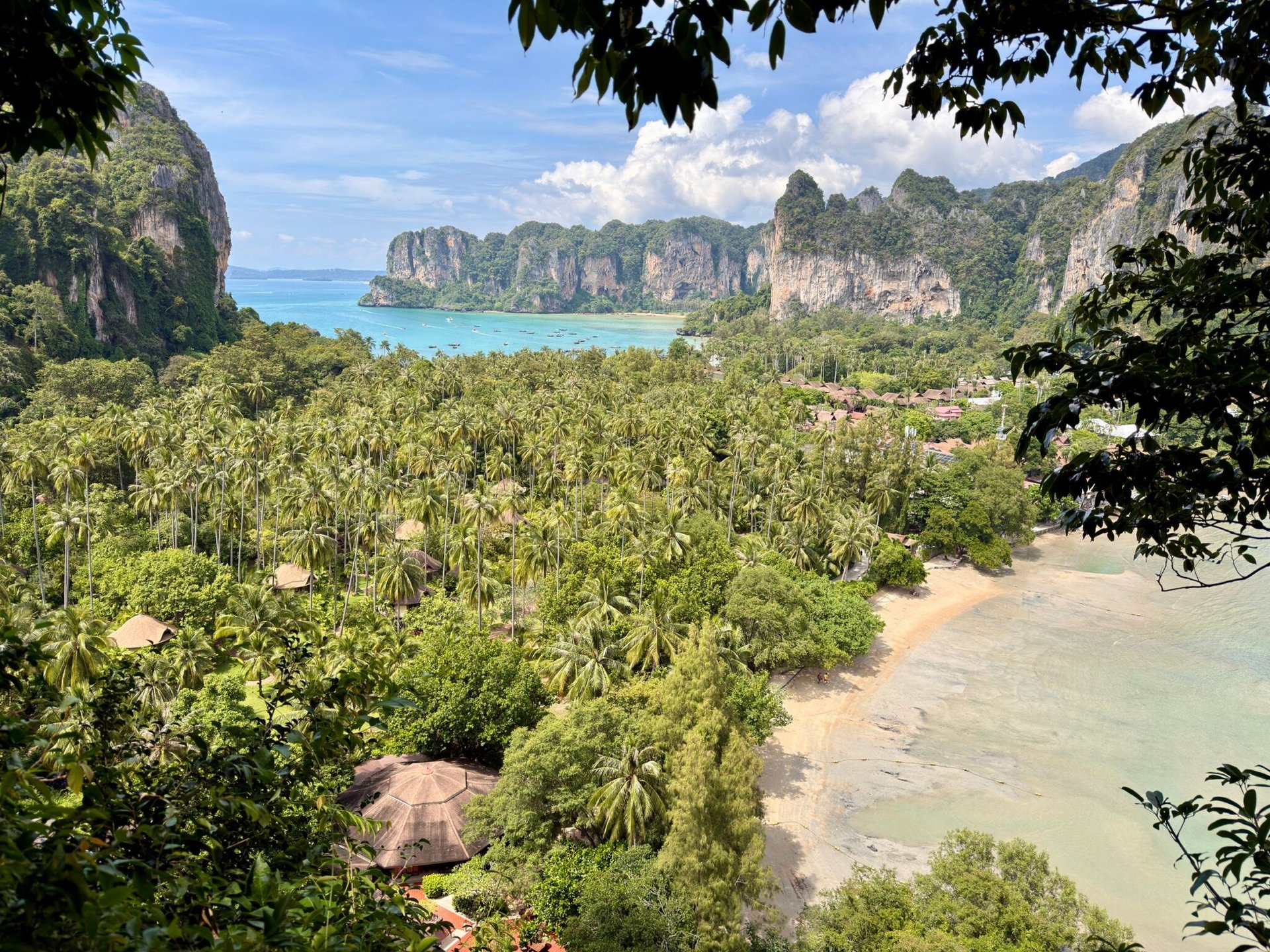 Breathtaking view of tropical beach with lush greenery and cliffs in Krabi, Thailand.