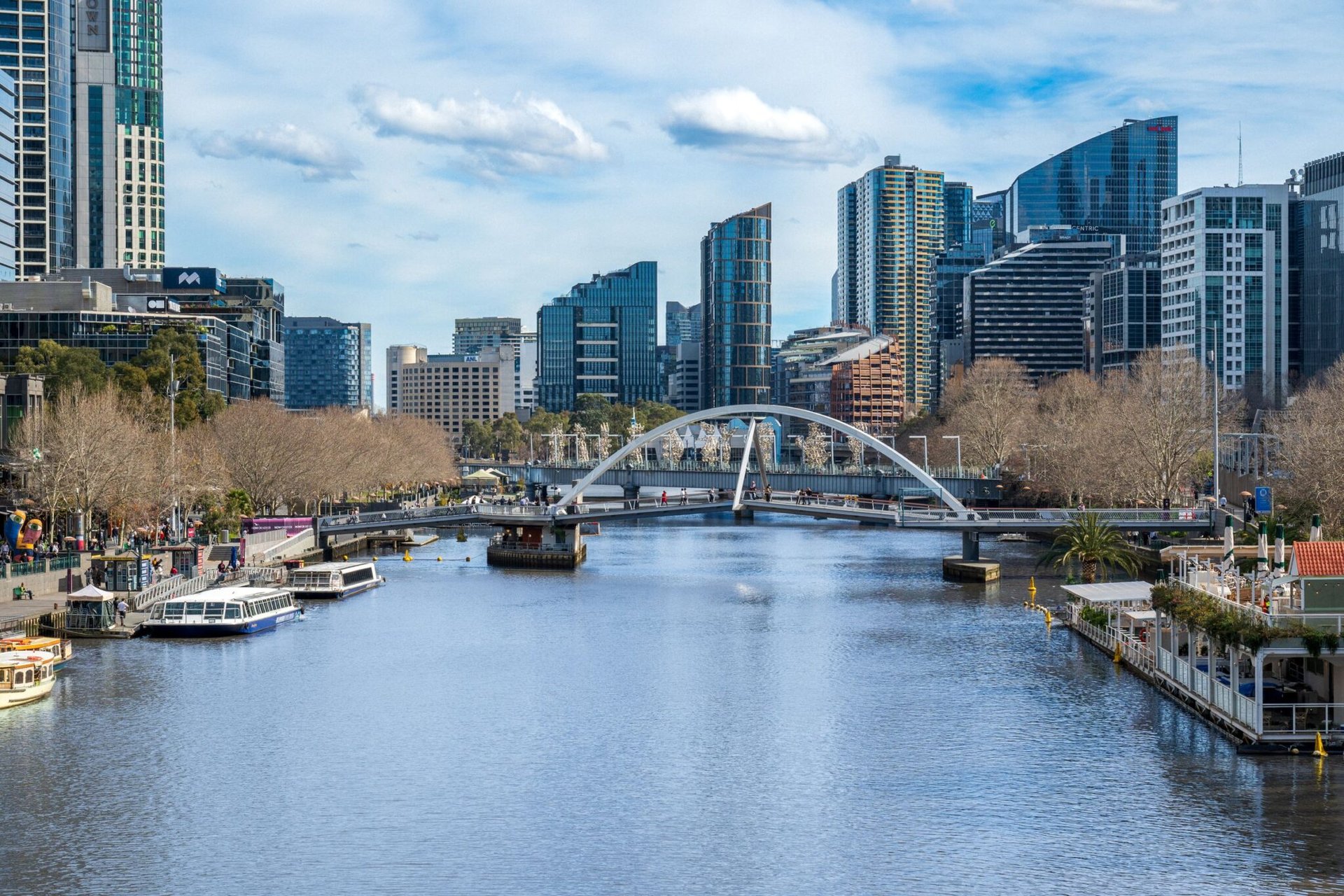 A breathtaking view of Melbourne skyline and Yarra River with a pedestrian bridge in Victoria, Australia.