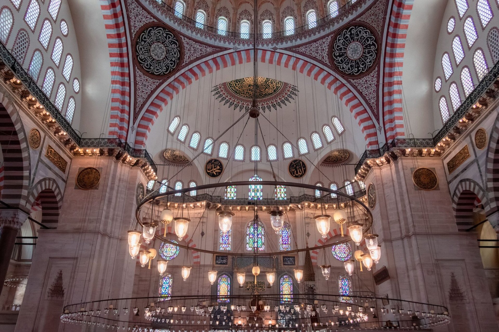 A stunning view of the intricate ceiling and lights inside the historic Süleymaniye Mosque in Istanbul.