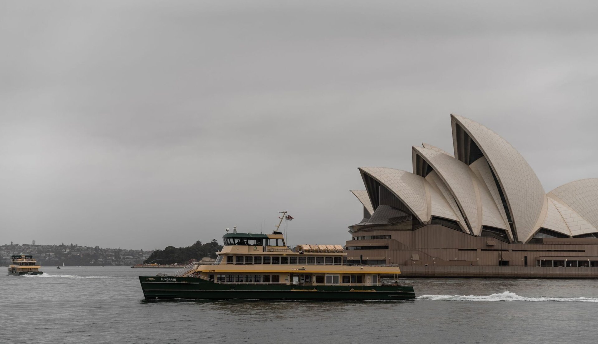 Modern cruise boat floating near futuristic white Sydney Opera House in expressionist style with large concrete shells on overcast day