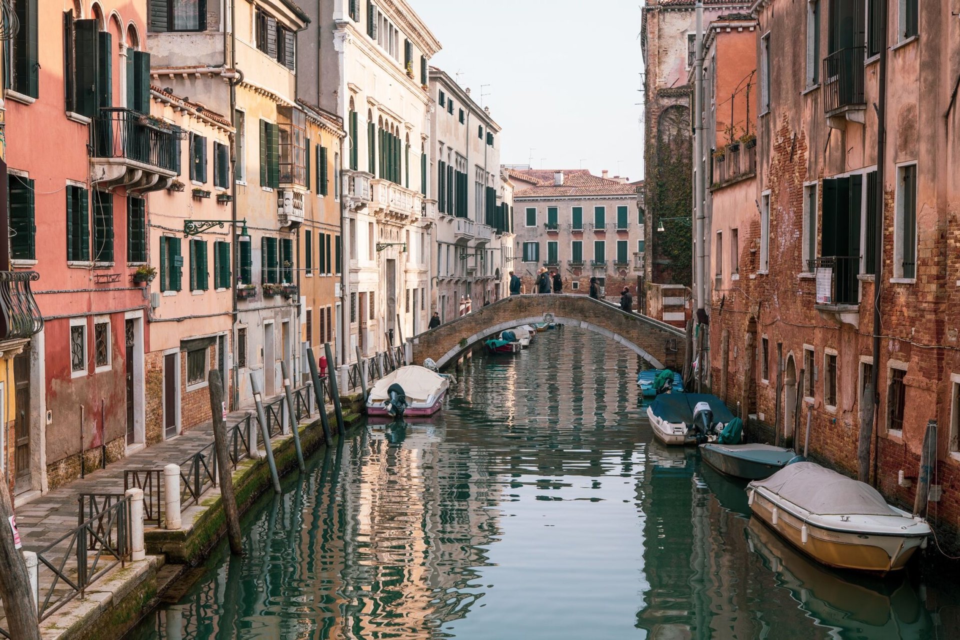 Picturesque view of a Venetian canal with a charming stone bridge and historic buildings, Venice, Italy.