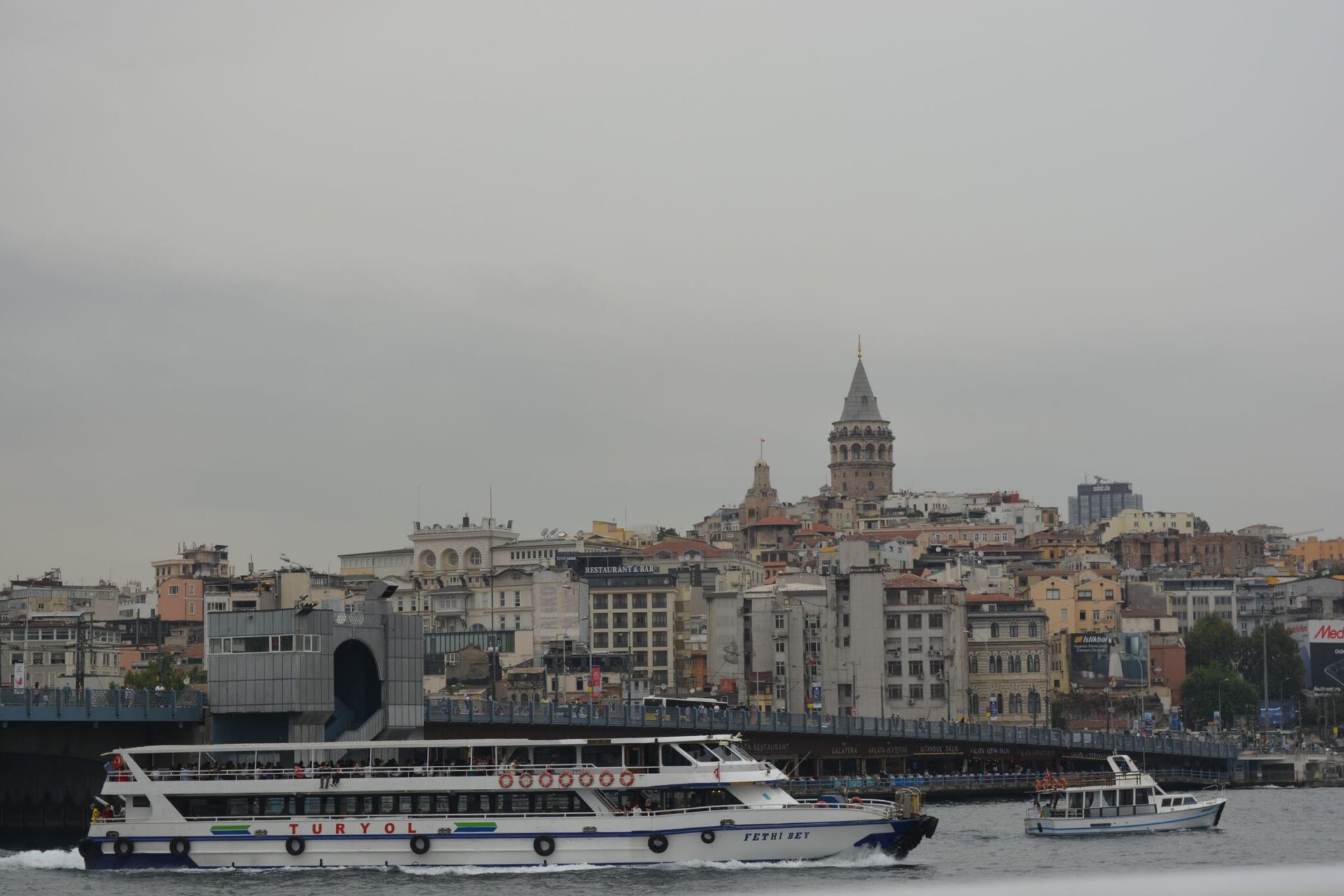 Ferry traversing the Bosphorus near Istanbul's iconic Galata Tower.